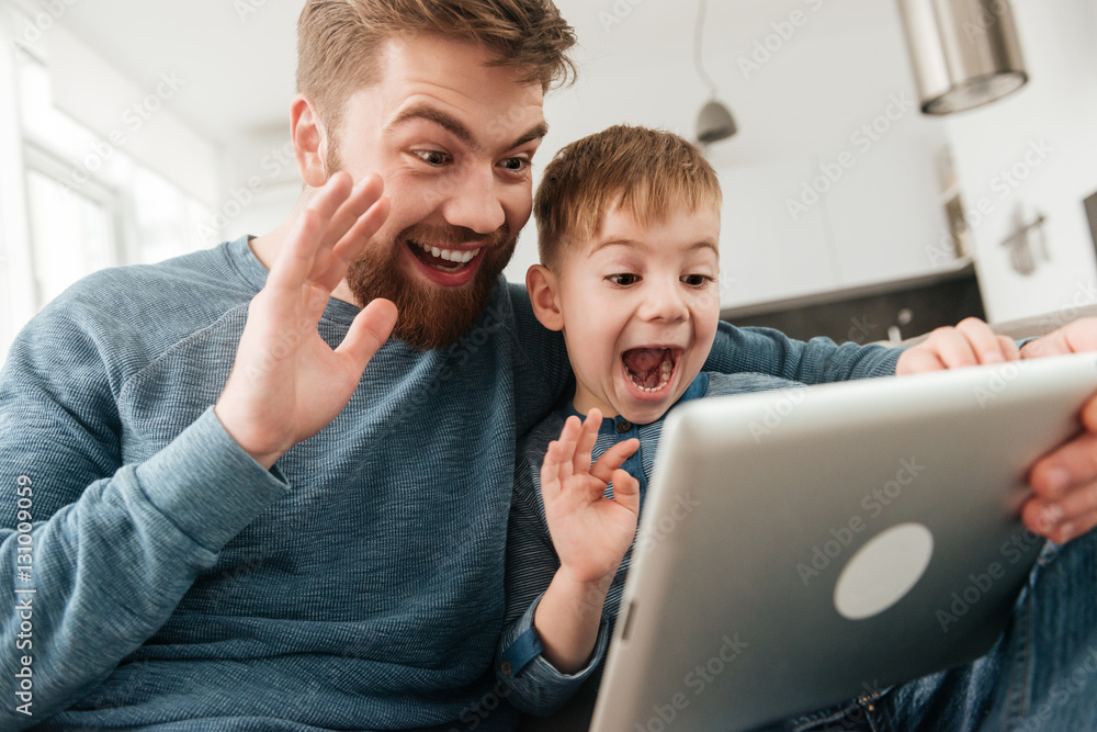 Cheerfu father talking to friends by tablet computer with son. Cheerfu father talking to friends by tablet computer with son.