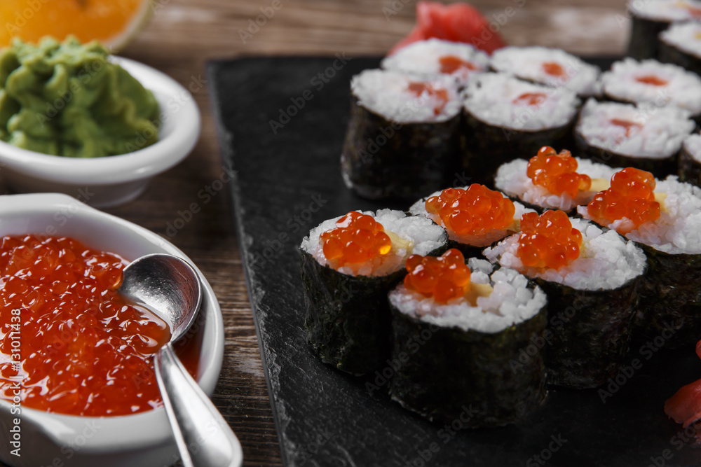 sushi rolls and ingredients served on a wooden surface sushi rolls and ingredients served on a wooden surface