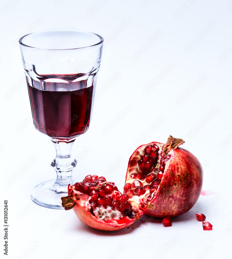 Sliced pomergranate and glass of juice isolated on white Sliced pomergranate and glass of juice isolated on white