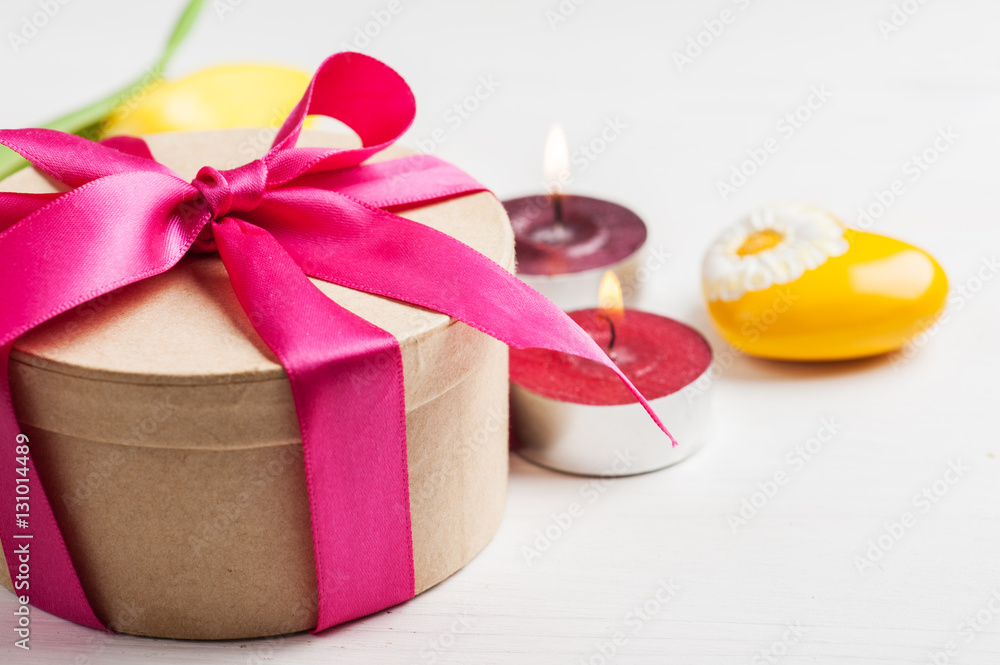 Lit candles and gift box with red ribbon Lit candles and gift box with red ribbon