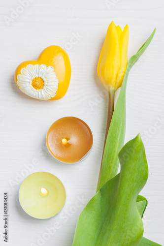 Yellow tulip, lit candles and heart