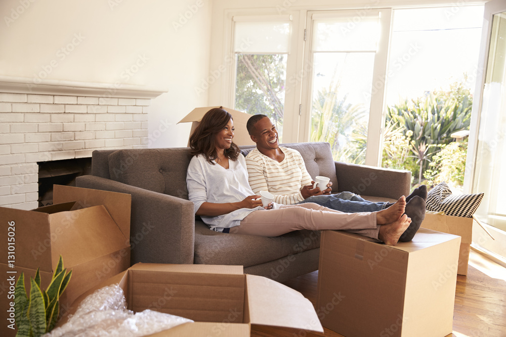 Couple On Sofa Taking A Break From Unpacking On Moving Day Couple On Sofa Taking A Break From Unpacking On Moving Day
