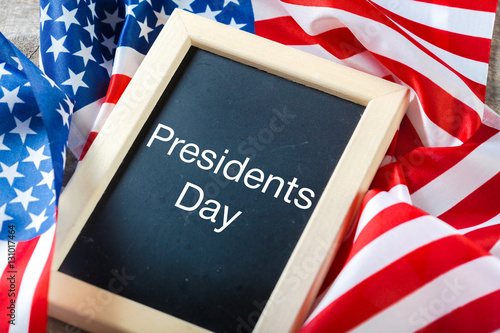 the text happy presidents day written in a chalkboard and a flag of the United States