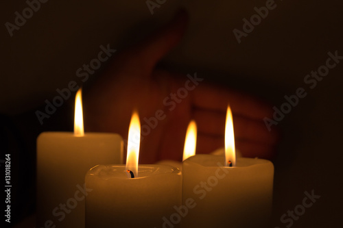 hand behind burning candles