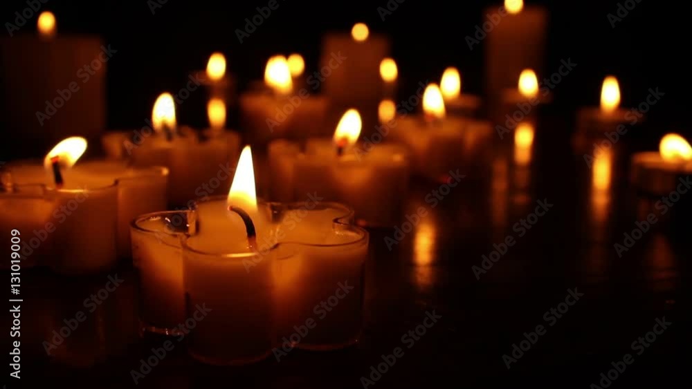 Small flower shape Candles burning at night on a wooden table. Candle lights and bokeh lights in the background Small flower shape Candles burning at night on a wooden table. Candle lights and bokeh lights in the background