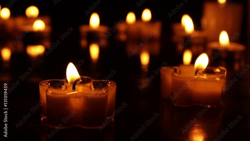 Small flower shape Candles burning at night on a wooden table. Candle lights and bokeh lights in the background Small flower shape Candles burning at night on a wooden table. Candle lights and bokeh lights in the background
