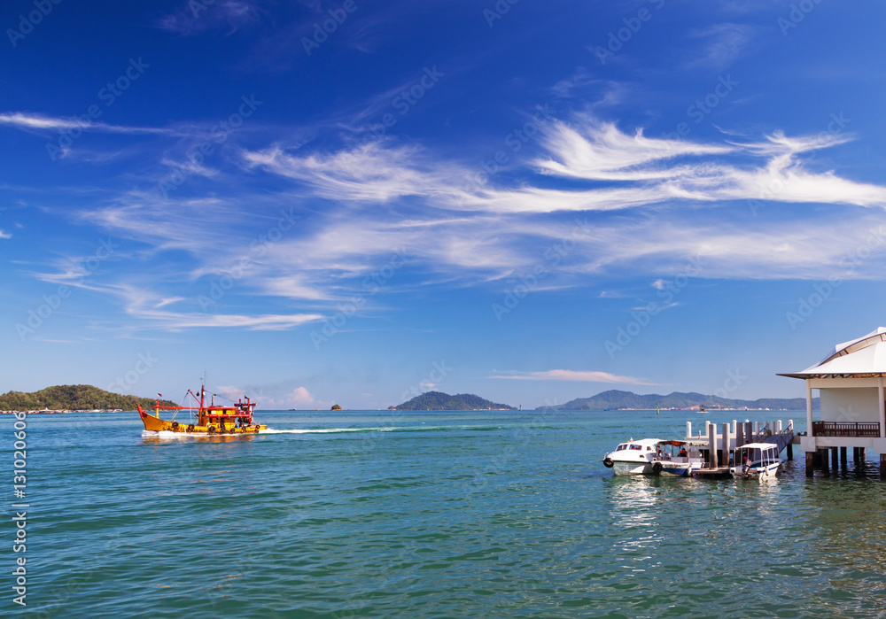 Obraz premium Seascape with boats and picturesque clouds. Borneo island, Malaysia.