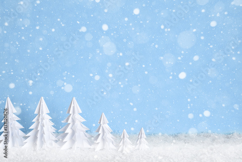 Winter Christmas minimalist background with white paper trees on blue drawing snowflakes
