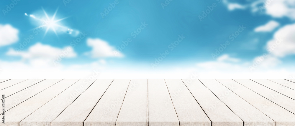 Panorama of modern wooden tabletop with blurry cloudscape summer Panorama of modern wooden tabletop with blurry cloudscape summer