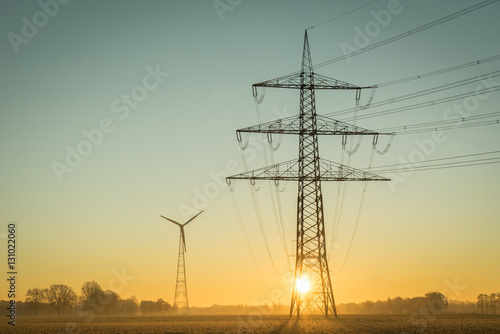 Netzausbau - Erneuerbare Energien, Strommast vor aufgehender Sonne