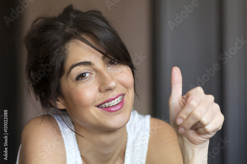 beautiful woman with braces thumbs up