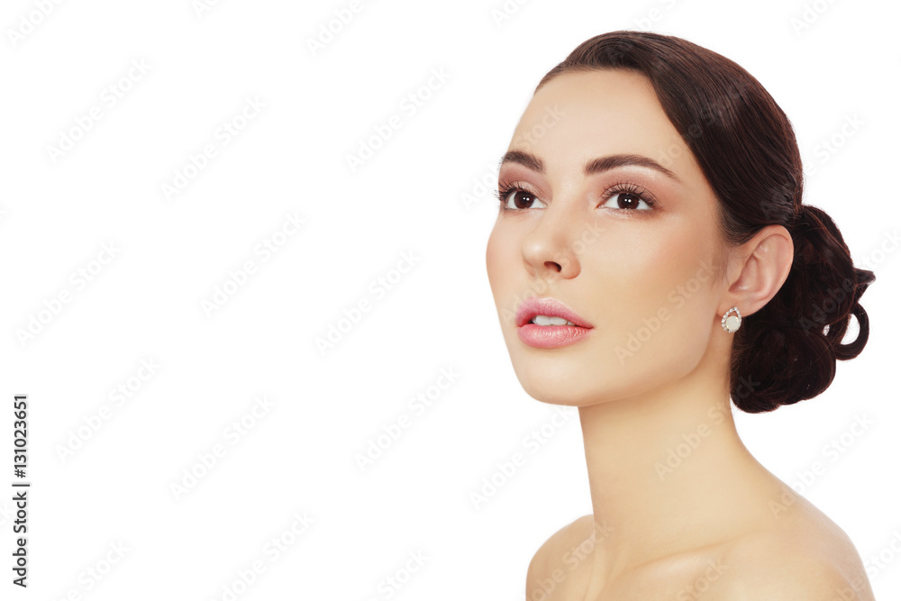 Portrait of young beautiful woman with clean make-up and prom hairdo looking upwards over white background, copy space Portrait of young beautiful woman with clean make-up and prom hairdo looking upwards over white background, copy space