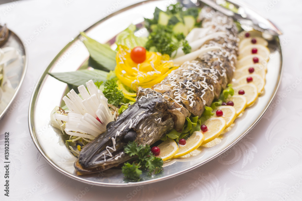 Stuffed pike decorated with vegetables and the greens. Very beautiful restaurant dish Stuffed pike decorated with vegetables and the greens. Very beautiful restaurant dish
