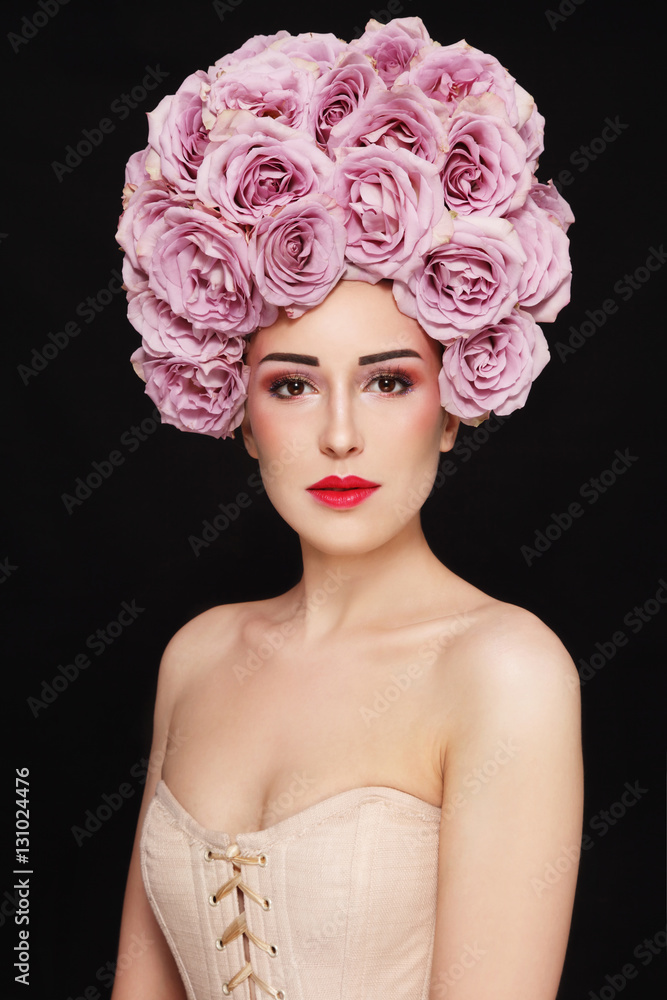 Young beautiful girl in corset and vintage style wig of roses 