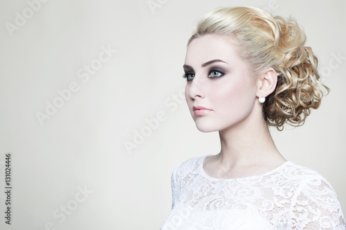 Young beautiful blonde bride with stylish prom hairdo and make-up