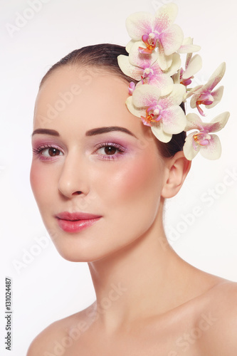 Portrait of young beautiful happy healthy woman with fresh make-up and white orchid
