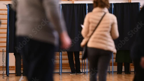 Unrecognizable people casting their votes inside voting booths during elections