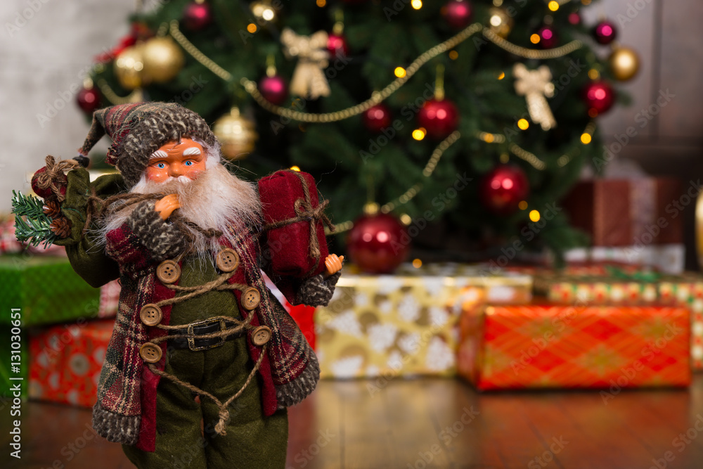 Santa Claus doll wearing traditional costume and holding a gift Santa Claus doll wearing traditional costume and holding a gift