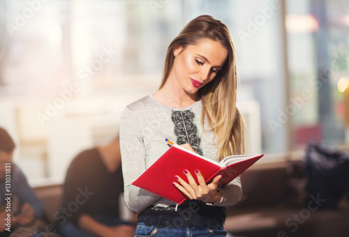 Beautiful young student with book, studying or preparing for exa