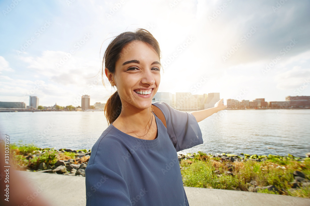 Beautiful young woman showing urban skyline Beautiful young woman showing urban skyline