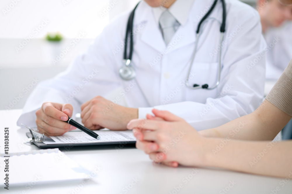 Doctor and patient are discussing something, just hands at the table Doctor and patient are discussing something, just hands at the table
