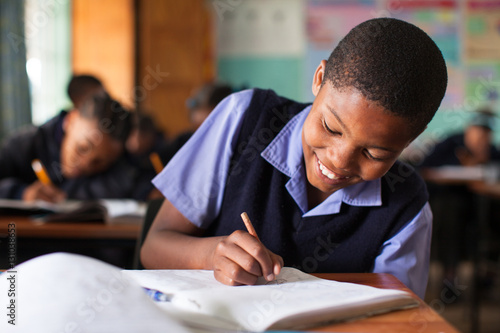 Young boy doing class work at a desk in a classroom in South Africa. photo