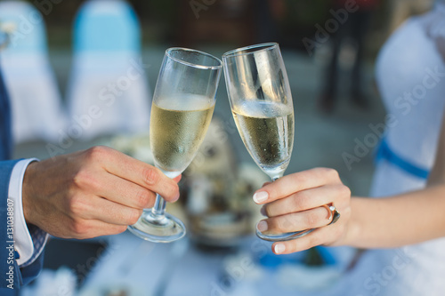 bride and groom holding beautifully decorated wedding glasses wi