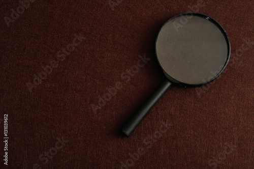Magnifying glass isolated on a brown background