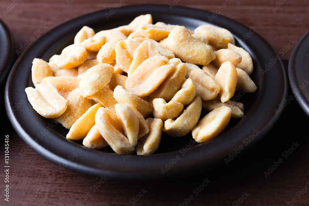 Hazelnuts and peanuts on a dark plate. Hazelnuts and peanuts on a dark plate.