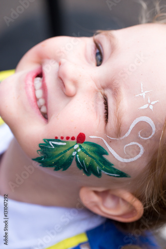 Baby caucasian girl toddler in profile with colorful christmas f