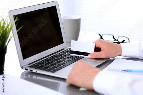 Close up of business woman hands using credit card and laptop computer © rogerphoto