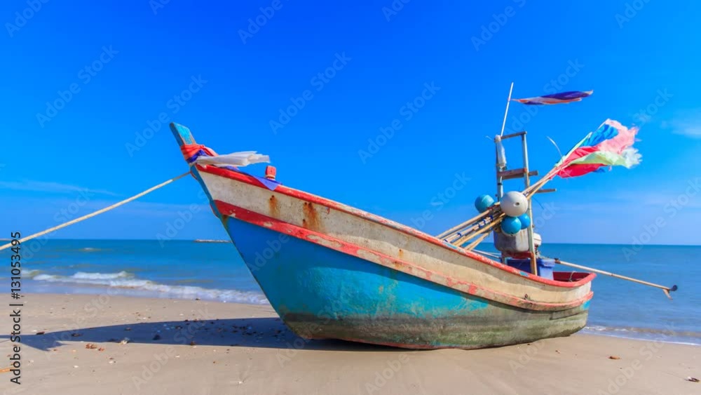 the alone fishing boat on the beach with blue sky in Thailand ocean the alone fishing boat on the beach with blue sky in Thailand ocean