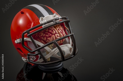 American football concussion protocol concept with a brain wearing a football helmet for protection with copy space