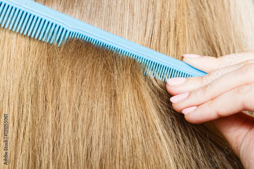 Close up of blue comb in blonde hair.