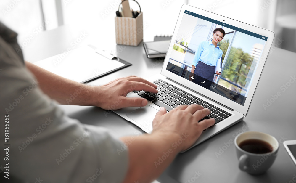 Fototapeta premium Man video conferencing with lawyer on laptop. Video call and online service concept.