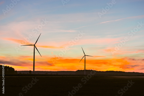 Silhouette of wind turbine on sunset