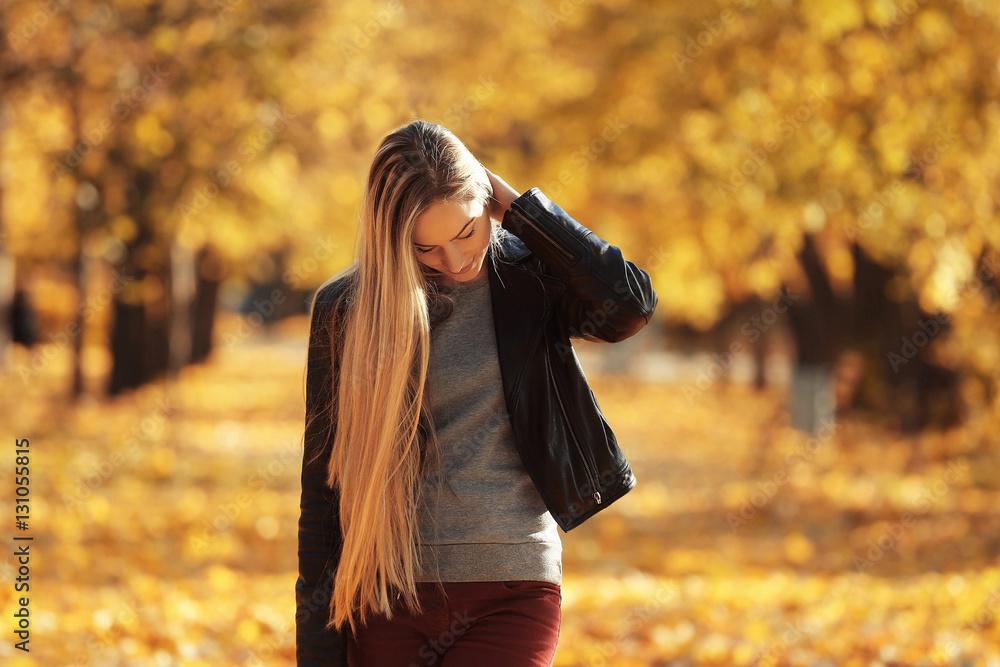 Beautiful young woman in autumn park on sunny day