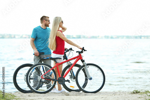 Happy couple with bicycles on the beach