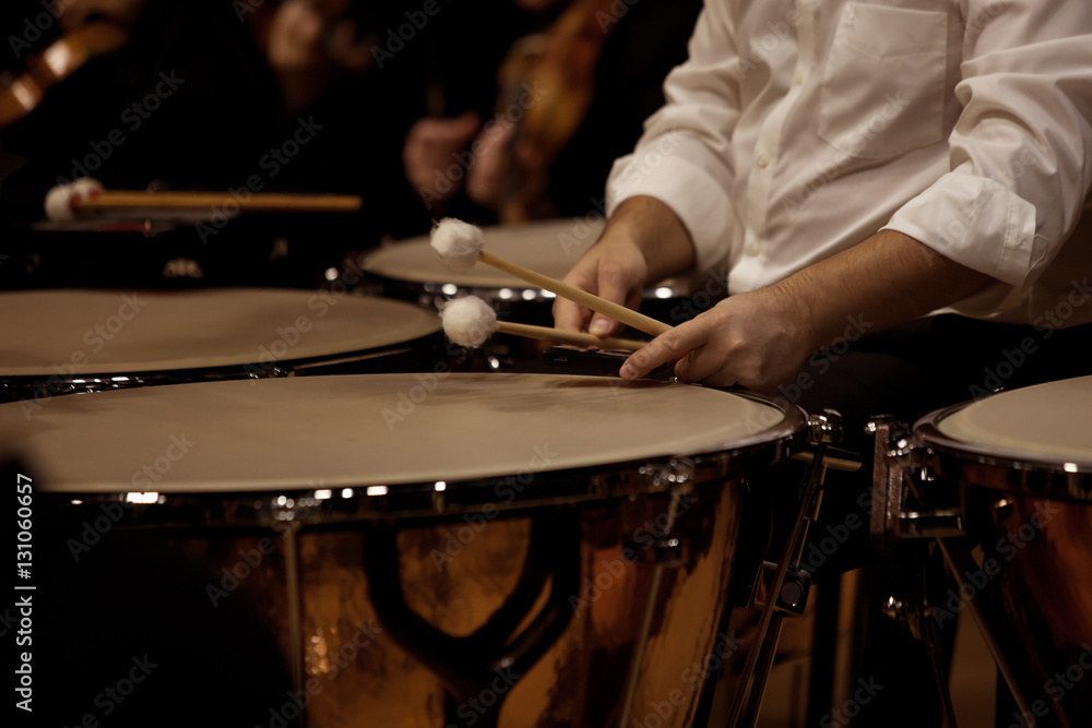  Hands musician playing the timpani in the orchestra closeup in dark colors