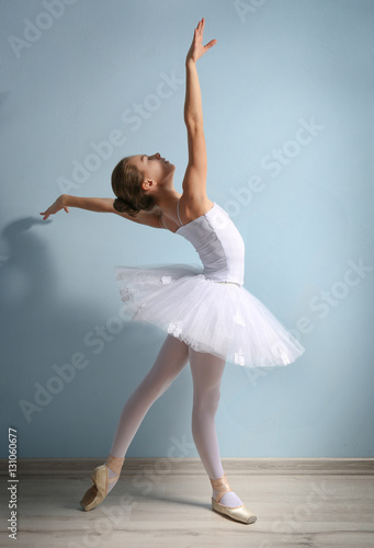 Fototapeta Naklejka Na Ścianę i Meble -  Young beautiful ballerina on wall background
