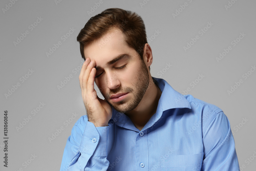 Depressed young man on grey background Depressed young man on grey background