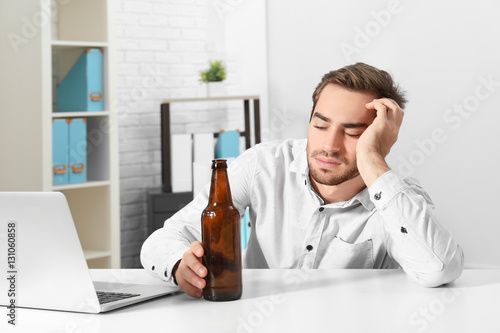 Tired handsome man with bot...