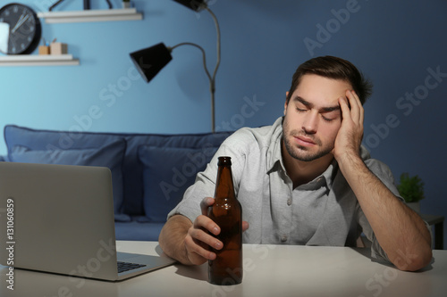 Tired young man with bottle...