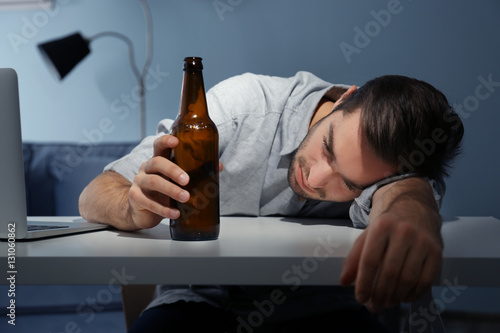 Tired young man with bottle...