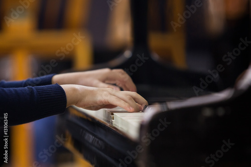 Hands of a child playing the piano closeup 