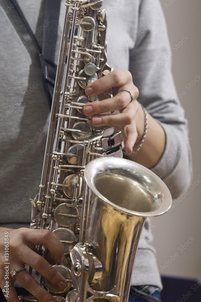 Fototapeta premium Hands girl playing the saxophone