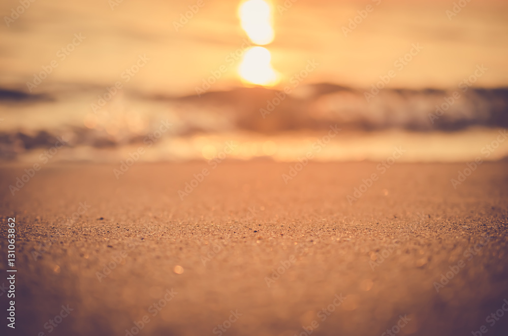 Blur tropical sunset beach with bokeh sun light wave abstract background.