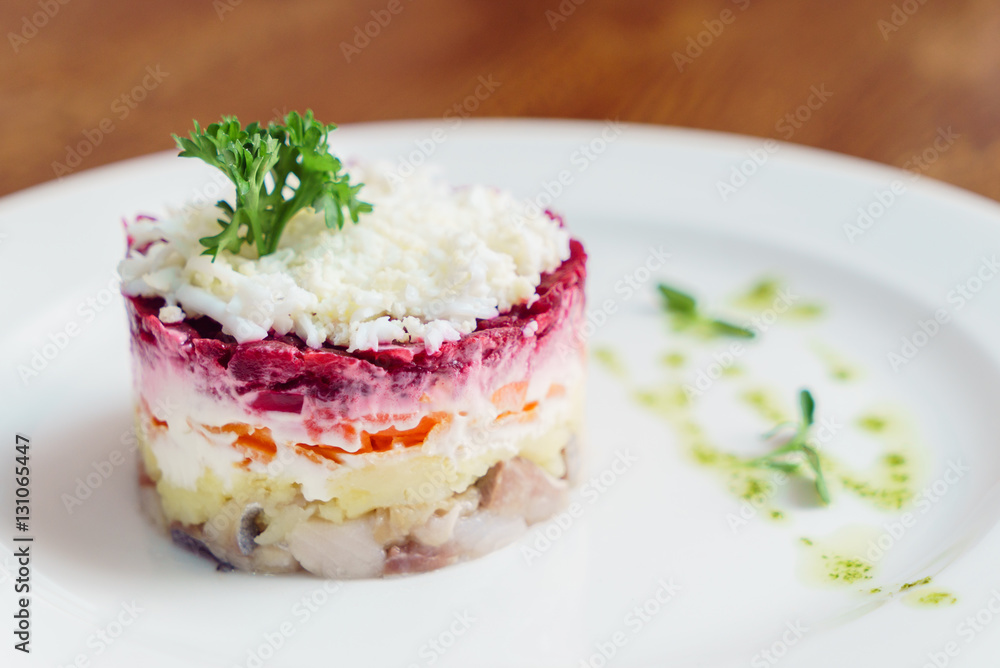 layered salad with herring, beets, carrots, onions, potatoes and eggs close-up on a plate layered salad with herring, beets, carrots, onions, potatoes and eggs close-up on a plate