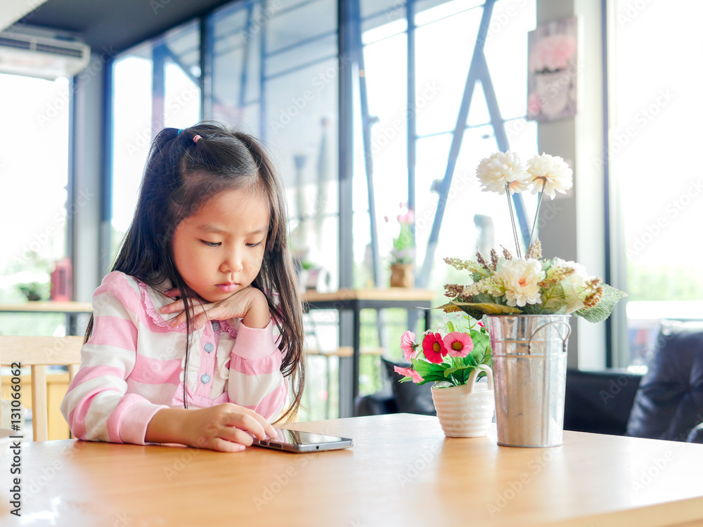 Portrait of Asia pretty little girl play mobile phone Portrait of Asia pretty little girl play mobile phone