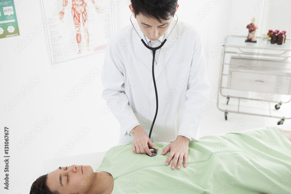 The doctor is applying a stethoscope to a man The doctor is applying a stethoscope to a man